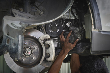 Auto mechanic replacing a car AC compressor ,car AC compressor replacement service and repair in garage shop.