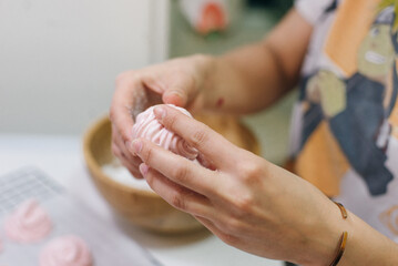 Homemade pink marshmallows on baking paper background on the kitchen