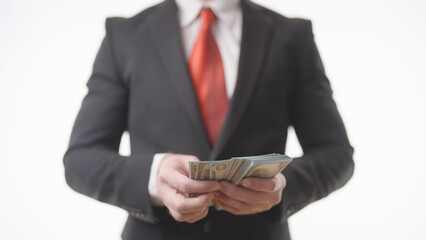 Headless businessman in suit counting a pack of money