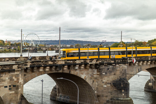Dresden, Saxony, Germany 28th October 2023: Yellow DVB train drives over a bridge downtown in Dresden City