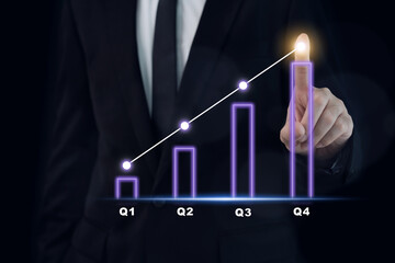 Businessman pointing his finger on the holographic or hologram bar chart showing a growth of business in quarter.