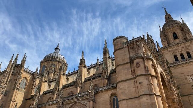 Beautiful filming of the upper part of the New Cathedral of Salamanca, the west fa&ccedil;ade where we see the Clock Tower, the large dome and many decorative spiers, all in a Plateresque Gothic style.