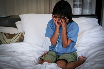 Crying girl, victim of bullying, abuse, violence, depressed patient, offering psychotherapy sitting on the bed. She was bullied, unhappy, upset, feel sick. Lonely concept.