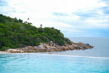 Fototapeta premium Beautiful view from infinity pool at luxury hotel against ocean front, tropical resort. Relaxing, summer, travel, holiday, vacation and weekend concept.