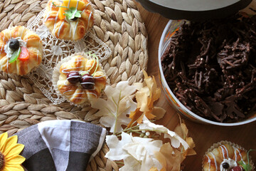 Homemade Chocolate Stick Candy with Sparkling Sugar in a Festive Halloween Bucket with Light Pastries on Wicker Place Mats with Sunflower and Buffalo Check Decor