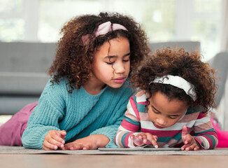 Sisters on floor, home and relax with tablet, typing and playing online games in living room. Kids, apartment and girls on carpet, tech and social media with digital app for fun and scroll for ebook