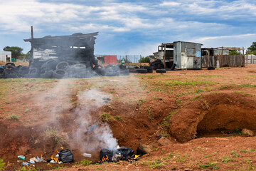ditch and garbage in the shanty town , shack made of corrugated sheet galvanized metal, township...