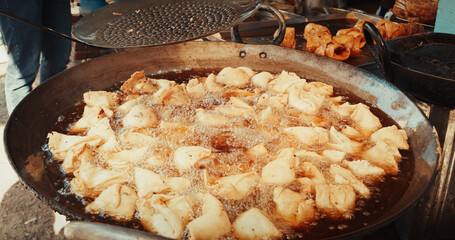 Man Cooking Fried Flatbreads In Oil Close-up View. Street Food Of India. Traditional Street Food Punjabi Samosa. Vegetarian Samsa Or Samosas. Popular Indian Snacks. Fried Samosas