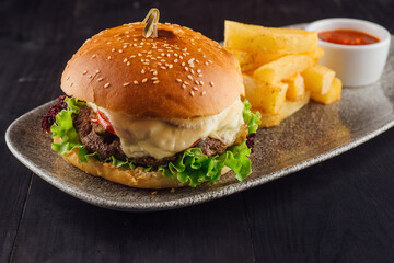 Delicious burger with beef, tomato, cheese and salad served on plate