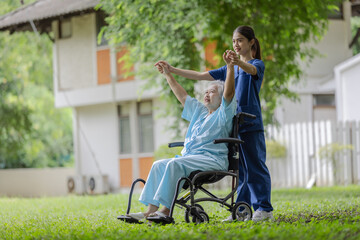 Compassionate Nurse Assisting an Elderly Woman in a Wheelchair with Physical Therapy Exercises in a...