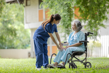 Compassionate Nurse Assisting an Elderly Woman in a Wheelchair with Physical Therapy Exercises in a...