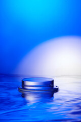 An empty transparent display platform for product display placed in the middle of the rippling blue lake. Minimalist background with lake and blue background suitable for cosmetic advertisement.