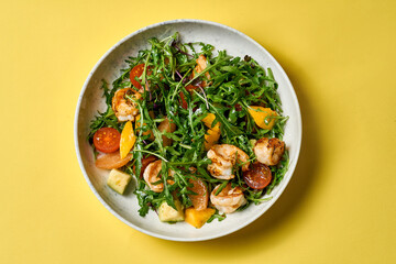 A vibrant and fresh salad featuring grilled shrimp, ripe avocado, juicy mango, and cherry tomatoes.