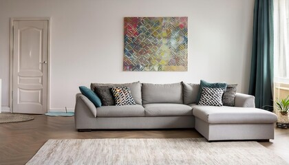 Bright living room interior with a grey corner couch, three patterned pillows, painting