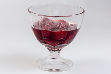 Strawberry jam with whole berries in glass dessert bowl