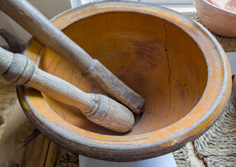 Old earthenware kitchen mortar and two wooden pestles in it