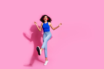 Full body photo of attractive young woman headphones dancing good mood dressed stylish blue clothes isolated on pink color background