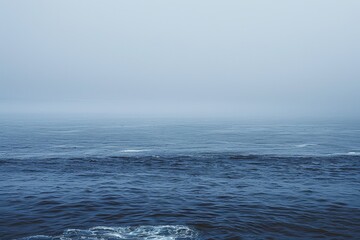 Fototapeta premium A vast body of water stretches under a cloudy sky, creating a serene and atmospheric scene, Subtle variations of navy creating a sense of calm