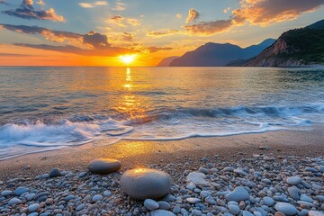 Obraz premium Sunset Over a Rocky Beach with Smooth Stones and Rolling Waves