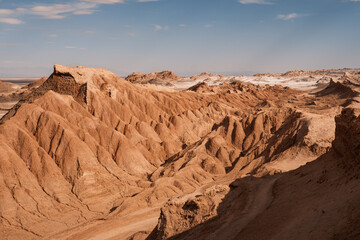 Rolling, rugged terrain of Cordillera del Sal showcases its unique ochre formations under a clear...