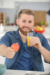 healthy man with glass of orange juice and an apple