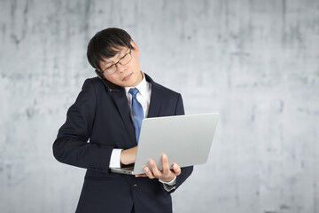 パソコンを使いながら電話するビジネスマン