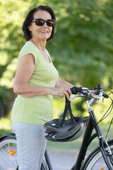 Obraz premium portrait of a happy senior woman holding a bicycle