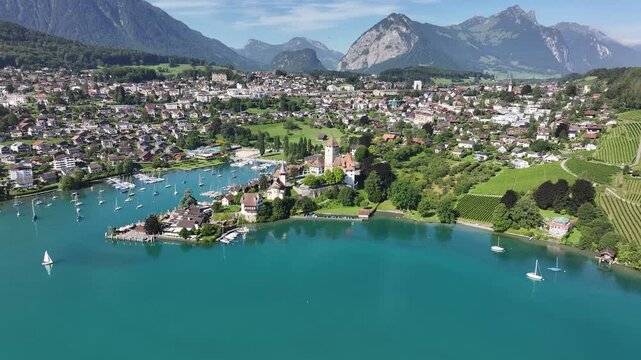 Spiez, a swiss town on lake thun with mountains in the background, on a sunny day, aerial view
