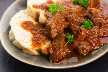 Beef goulash and dumplings (knedliky) on table