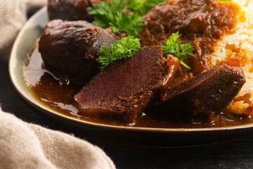 Stewed goose stomach.  Traditional Polish meat on a dark background.