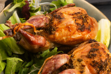 Baked tasty quails on ceramics plate with salad