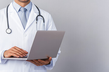 Healthcare professional in a lab coat using a laptop to access patient information, embodying the integration of technology in modern medical practice.