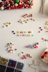 Friends forever written with colorful beads. Jewelry making supplies on the table. Making friendship bracelets concept. Flat lay.