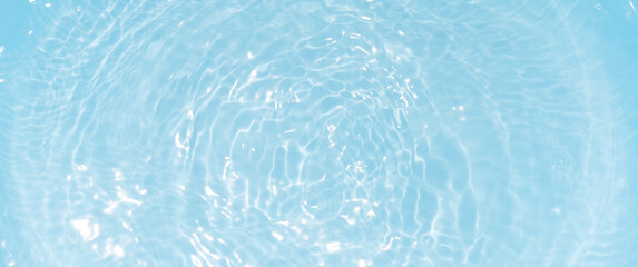 Blue water with ripples on the surface. Defocus blurred transparent blue colored clear calm water surface texture with splashes and bubbles. Water waves with shining pattern texture background.