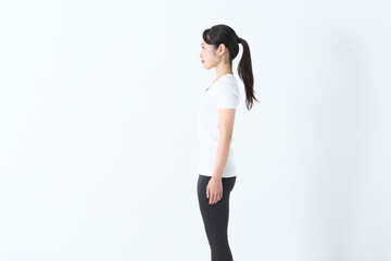 真横から見たTシャスにスパッツ姿の20代の女性