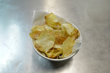 patate fritte artigianali in una coppa bianca sul bancone di una cucina in un ristorante