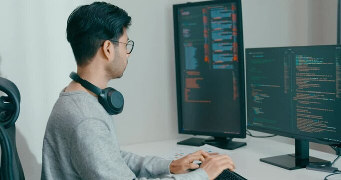 Young adult Asia male freelance eyeglasses typing write prompt AI bot IT app smart program nomad, video game, terminal with coding, user interface, designer, big data center on desktop computer.