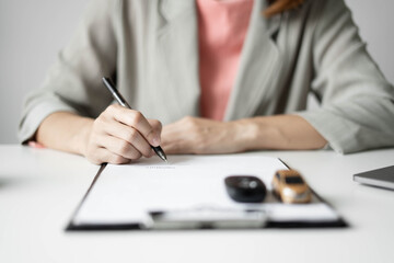 Naklejka premium Car dealer businesswoman signing car insurance document or lease paper. Car insurance, loans and Car rentals concept