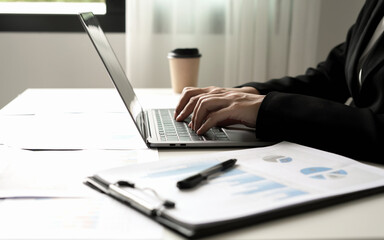 Asian businesswoman sit at their desks and calculate financial graphs showing results about their investments and plan successful business growth process