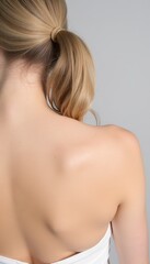 Fototapeta premium Close-Up View of a Woman's Back with a Ponytail Hairstyle