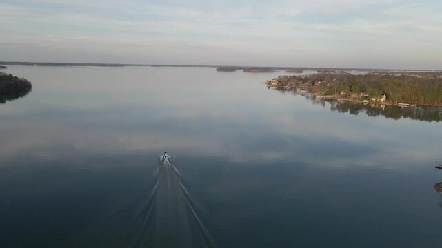 Wide shot of a boat cruising on the lake in the evening. Lake Murray in South Carolina.