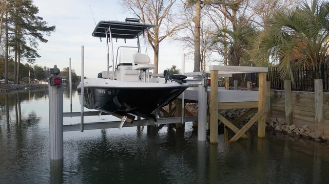Boat being raised on a boat lift at the lake in the evening. Lake Murray in South Carolina.