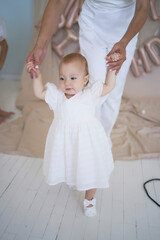 Fototapeta premium mother with a baby girl in a stylish white minimalist interior in white clothes