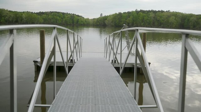 Afternoon walk on an empty boat dock on the lake while a fishing boat passes in the background. Lake Murray in South Carolina.