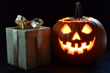 A Glowing Jack-o'-Lantern Beside a Gift Box