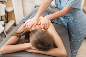 Obraz premium posture correction. Close-up of faceless physiotherapist giving back treatment to patient in physiotherapy room. Rehabilitation, therapeutic massage and manual therapy concept.