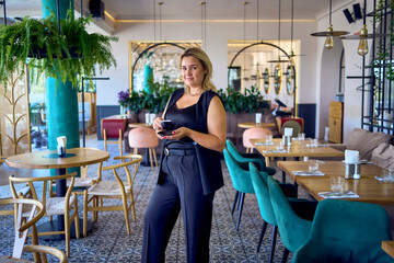 a   middle-aged plus size woman in old money style clothes in a fancy restaurant