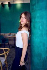 Fototapeta premium a 16-year-old teenage girl in old money style clothes in fancy restaurant