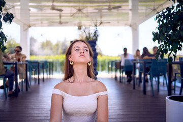 a    portrait of  16-year-old teenage girl in old money style clothes in  fancy restaurant