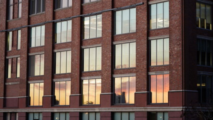 The city building view with the sunset sky reflected on the windows